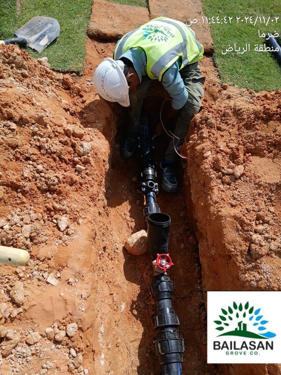 Worker installing an irrigation pipe network
