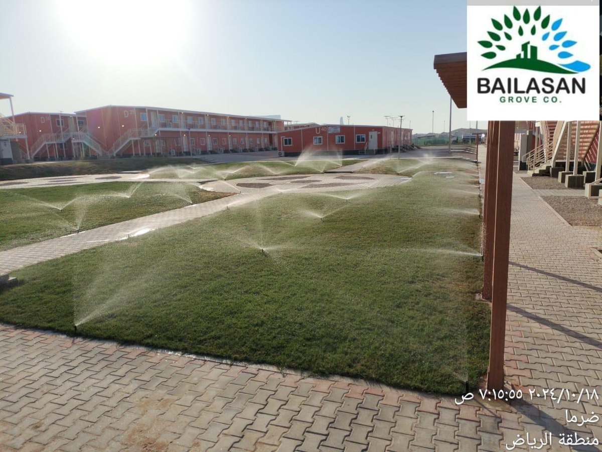 Sprinklers operating across a landscaped lawn
